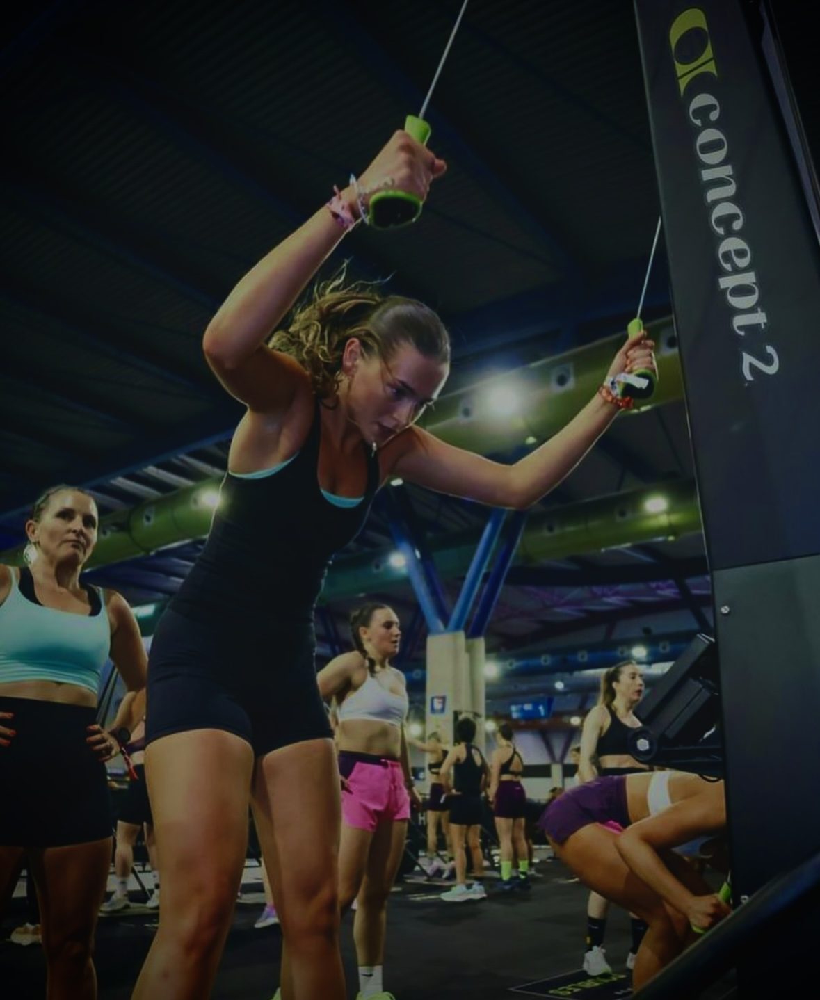 A coached Hevo class working through a SkiErg and strength circuit